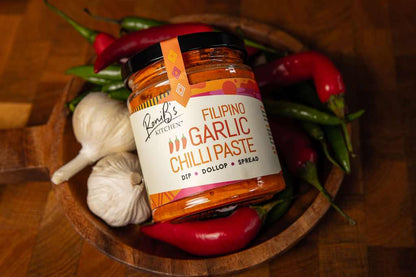 RoniBs Kitchen Filipino garlic chili paste hot sauce with Scotch bonnets, medium heat, vegan, in a jar with vibrant red chili and garlic.