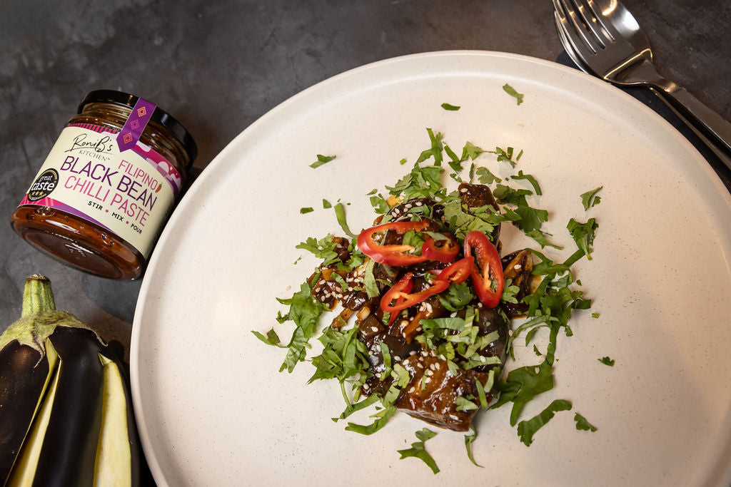RoniBs Kitchen Filipino Black Bean Chilli Paste hot sauce in a jar, featuring a spicy, dark chili and bean mixture for flavorful dishes.