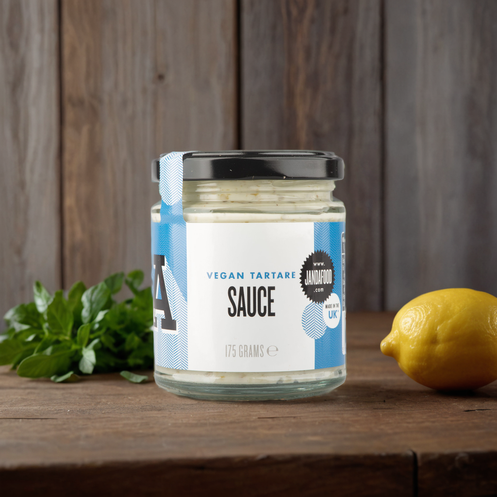 Vegan tartare sauce by Janda, creamy condiment with herbs and lemon, served in a small bowl on a rustic wooden table.