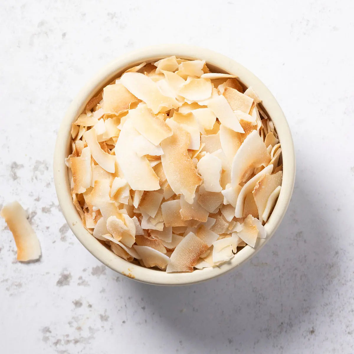 Whole Food Earth toasted and unsweetened coconut slices, natural nut and seed snack, showing golden-brown toasted coconut pieces.