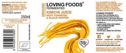 Assorted Loving Foods fermented vegetable juices including turmeric and kimchi flavors, in glass bottles on a rustic wooden table.