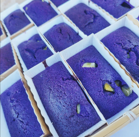 Slice of Ube and Mango free from cake from The Healthy Cake Company, showing vibrant purple ube and yellow mango layers.