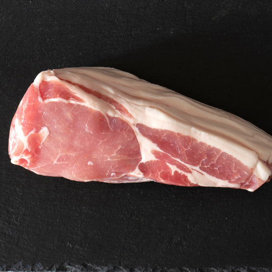 Primrose Herd Cornish Heritage Pork dry-cured smoked back bacon slices on a cutting board, showcasing crispy, golden-brown bacon.