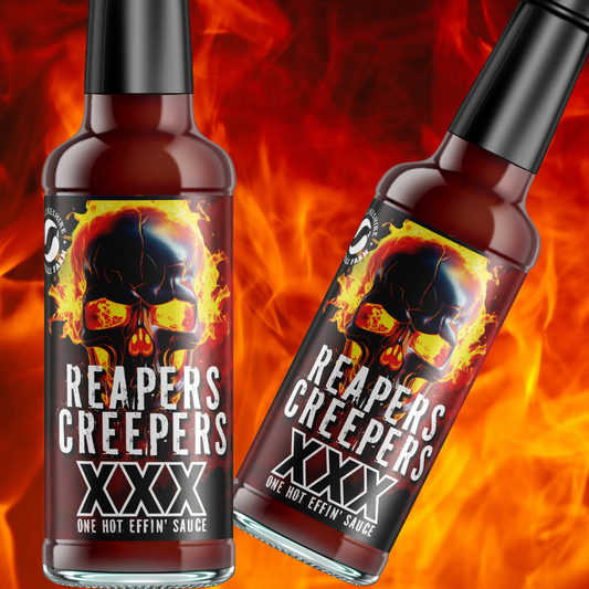 Pembrokeshire Chilli Farm Reapers Creepers XXX chili peppers on plant with green stems and vibrant red peppers in sunlight.