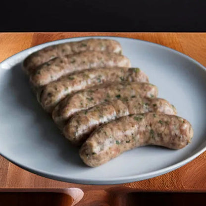 Close-up of Primrose Herd pork and leek sausages, showing their juicy, seasoned appearance and plump, grilled texture.