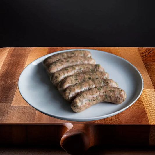 Close-up of Primrose Herd pork and leek sausages, showing their juicy, seasoned appearance and plump, grilled texture.