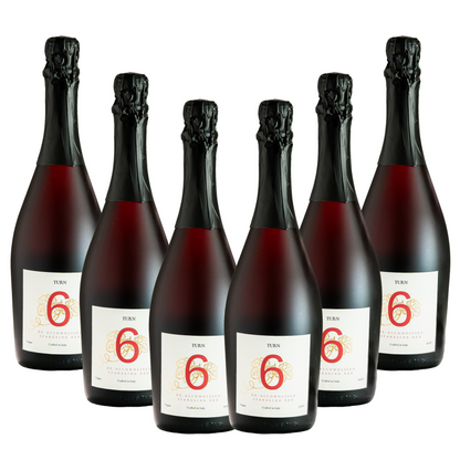 Six bottles of Turn 6 premium alcohol-free sparkling red wine in a case, showcasing elegant red wine bottles with foil caps.