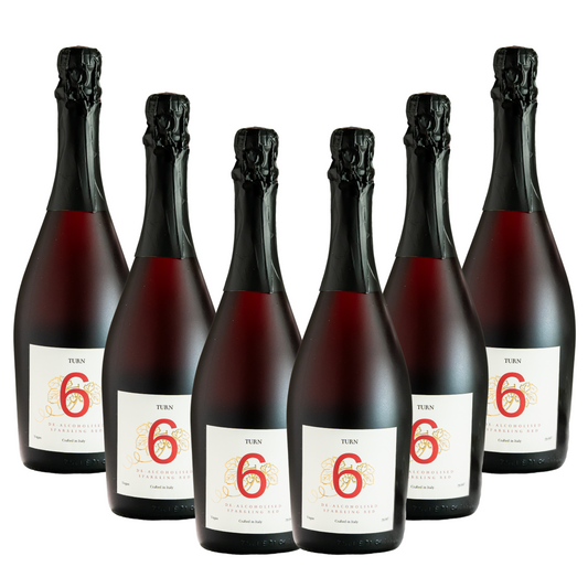 Six bottles of Turn 6 premium alcohol-free sparkling red wine in a case, showcasing elegant red wine bottles with foil caps.