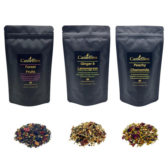 Assorted herbal loose leaf teas from Camellios in a decorative tea box with colorful tea leaves and herbs visible.