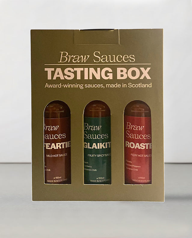 Braw Sauces vegan tasting box gift set with an assortment of plant-based sauces and condiments on a wooden surface.