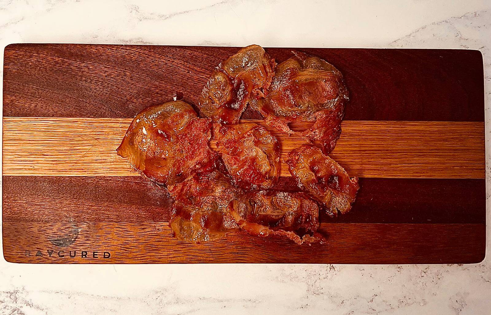 Slices of Bray Cured Guanciale charcuterie with marbled pork, ready for cooking or serving as a flavorful addition.