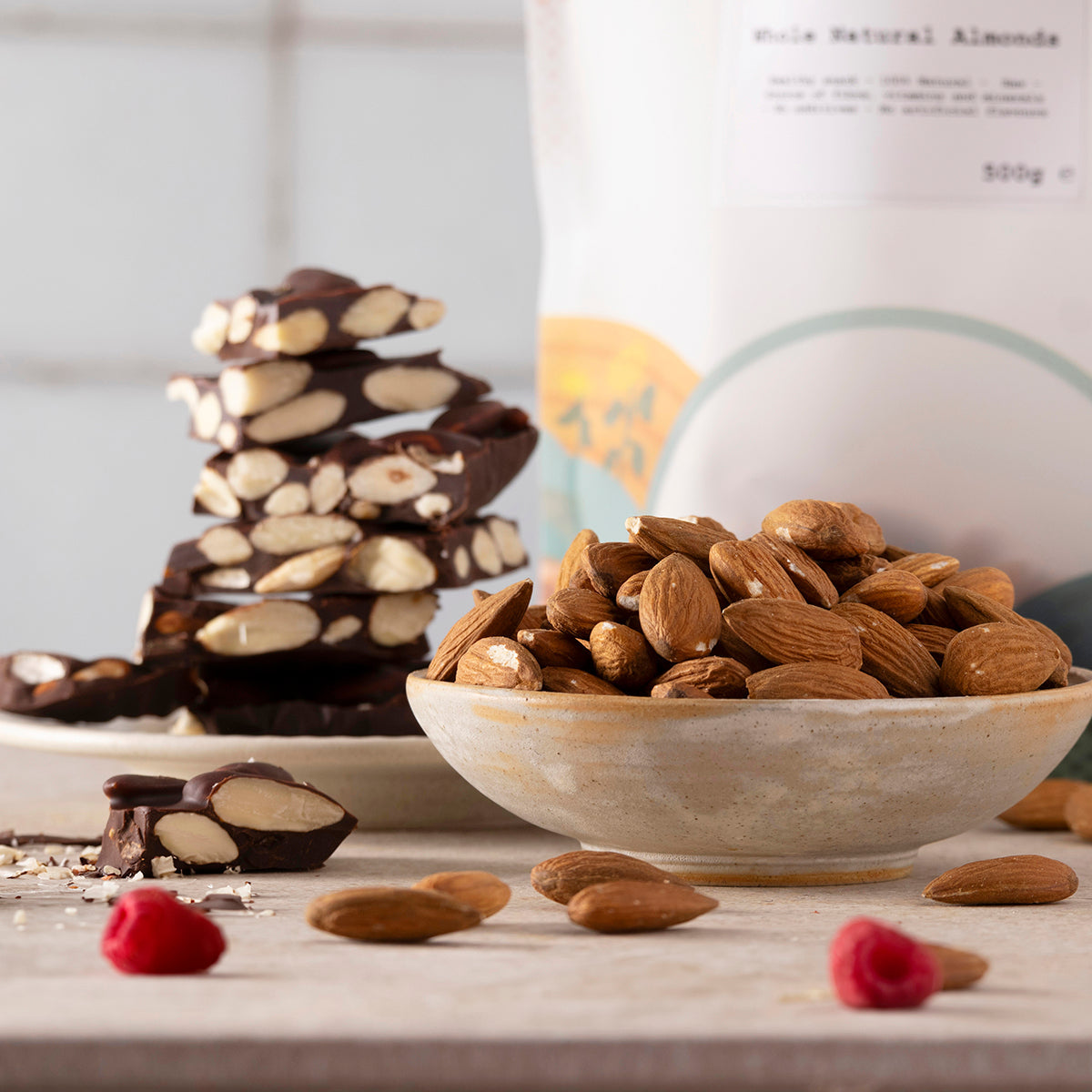 Bowl of whole natural almonds from Whole Food Earth, showing fresh, raw almonds with brown skins on a wooden surface.