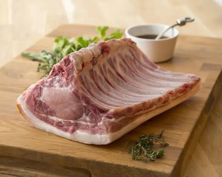 Whole bone-in pork loin from Primrose Herd, showing a fresh, pink pork loin with bone attached, ready for cooking or roasting.