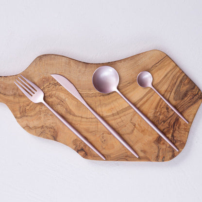 16-piece matte pink finish cutlery set by Orsina, including forks, knives, and spoons arranged on a white background.