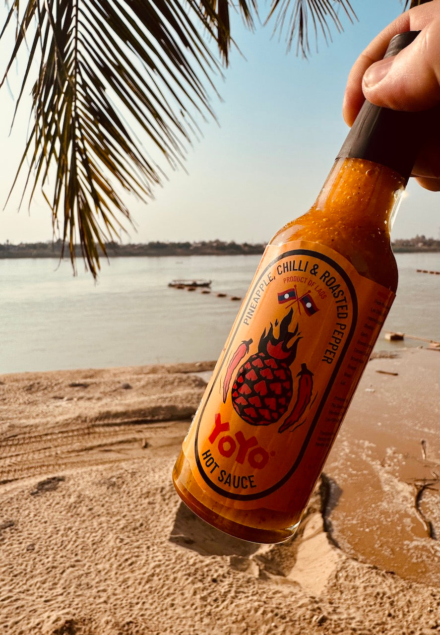 Limited edition Lao YoYo Pineapple Hot Sauce bottle from YoYo Laos Sauce, showcasing vibrant label and spicy pineapple flavor.