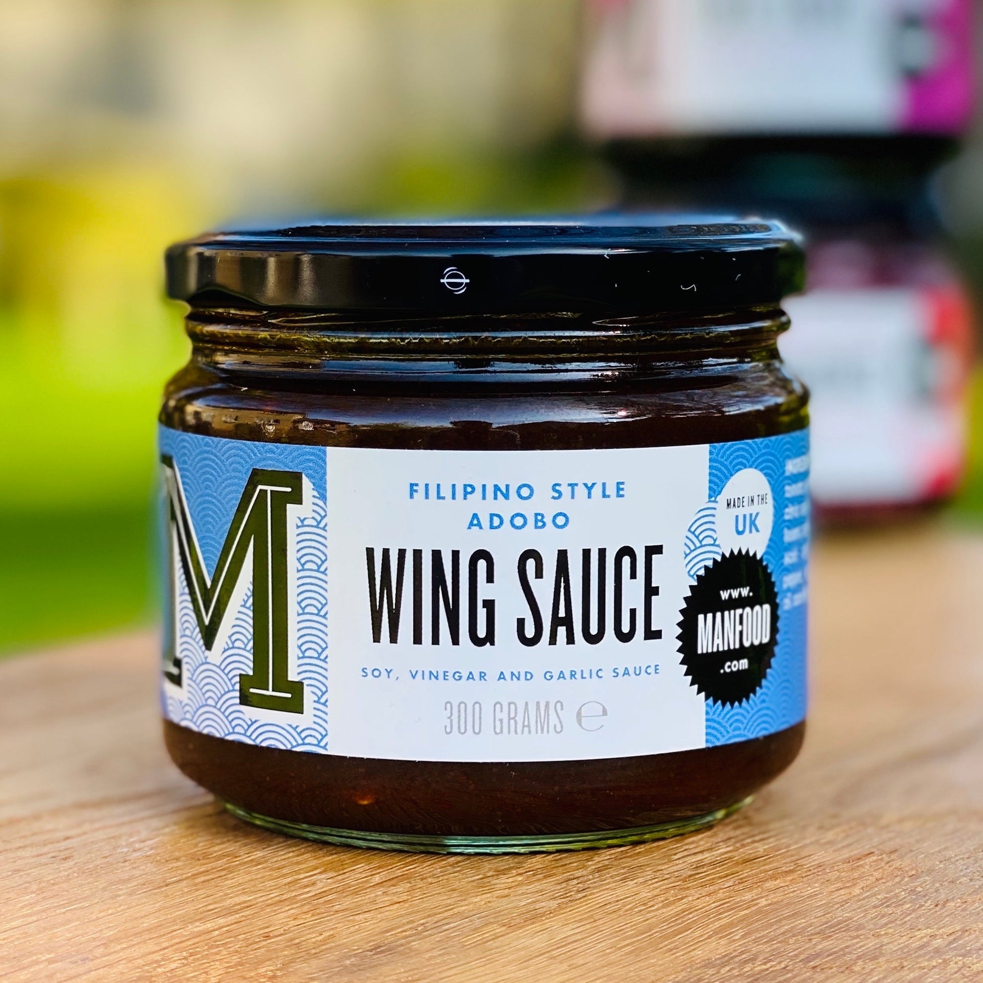 Manfood Adobo Wing Sauce in a jar, showcasing a rich, dark sauce with a smooth texture, ideal for wings and marinades.