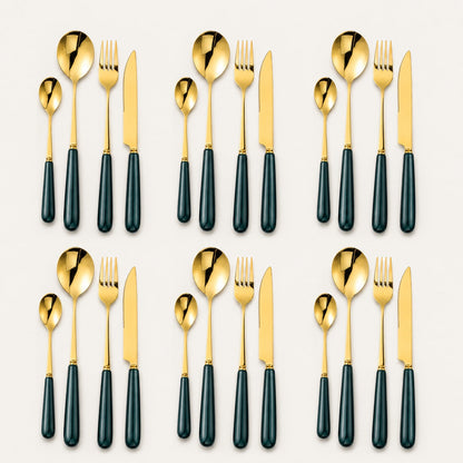 KitchBoom Aldermere 24-piece gold cutlery set with forest green handles, including forks, knives, spoons, and teaspoons arranged on a table.