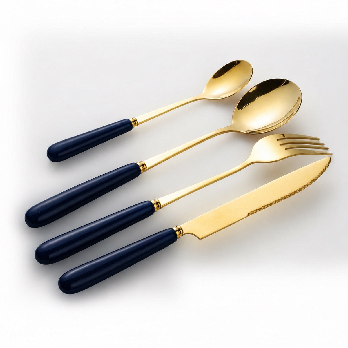 KitchBoom Aldermere 16-piece gold cutlery set with midnight navy ceramic handles, including forks, knives, spoons, and teaspoons.