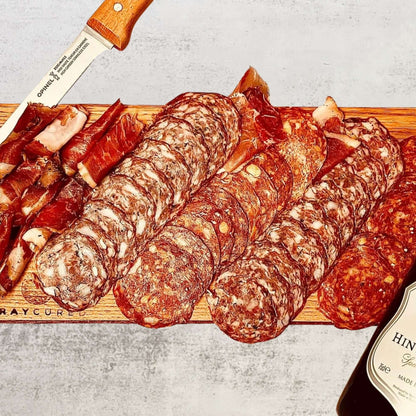 Bray Cured Bacchus Brut and British charcuterie hamper with assorted cured meats, cheeses, and accompaniments on a wooden board.