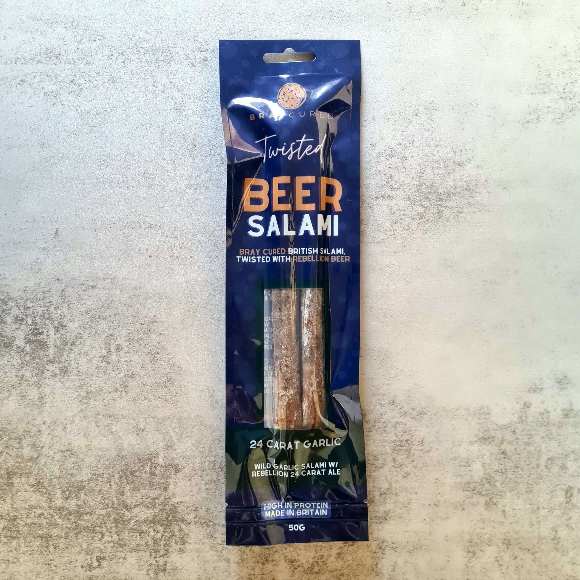 Bray Cured Beer Salami charcuterie with garlic, displayed in packaging, showcasing the flavorful sliced sausage on a wooden board.