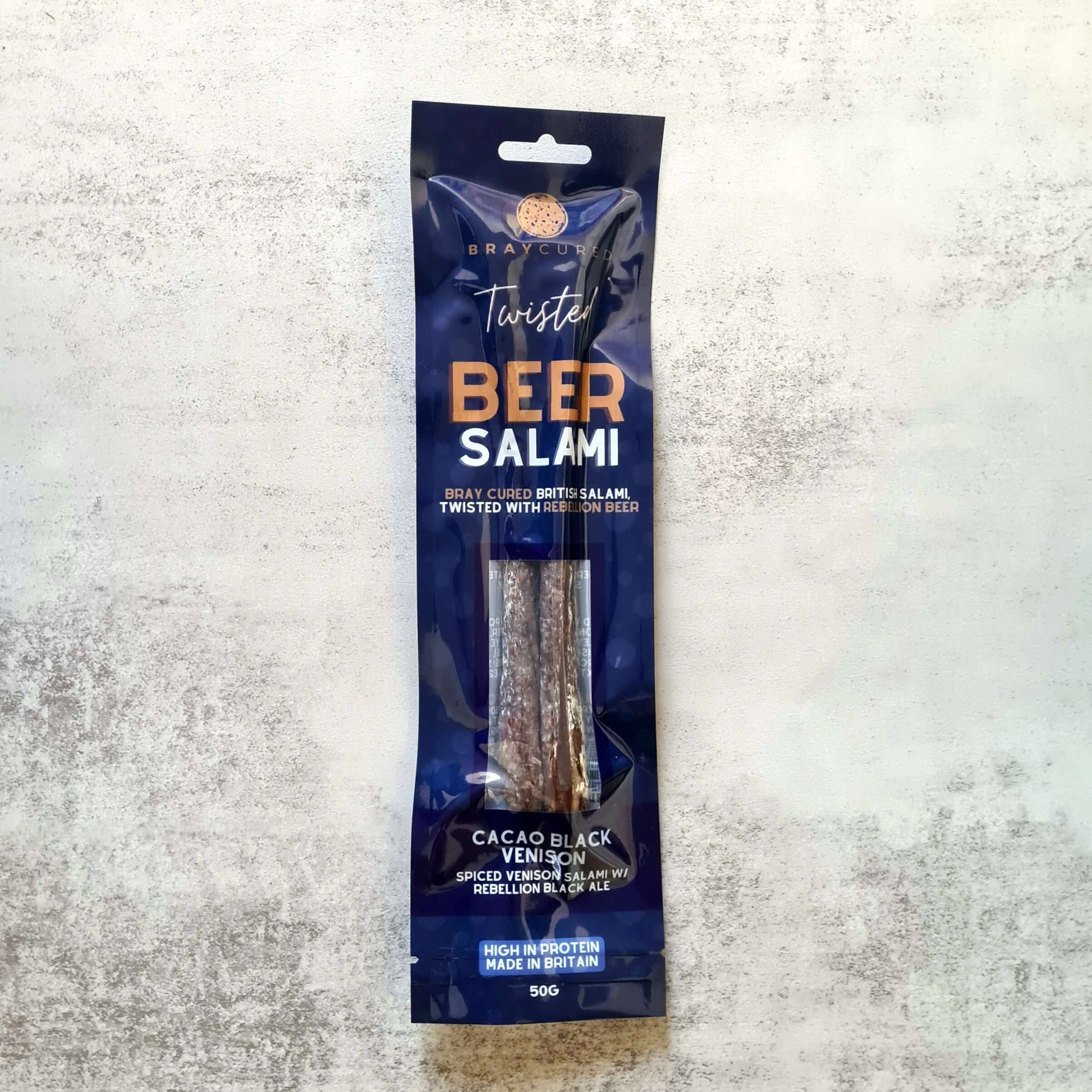 Bray Cured Beer Salami charcuterie pack featuring cacao, black venison, and slices of beer-infused salami on a wooden board.