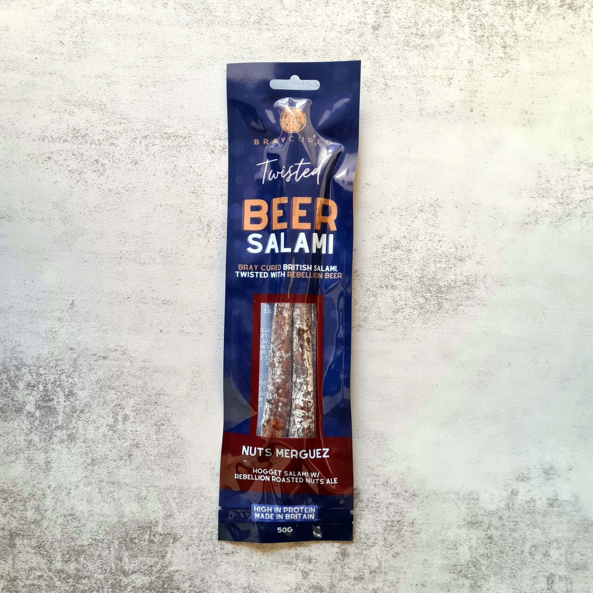 Bray Cured Beer Salami and Merguez charcuterie pack with nuts displayed on a wooden surface.