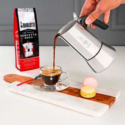 Bialetti Venus induction stovetop coffee maker by Brew Italia, stainless steel espresso pot with black handle and lid.