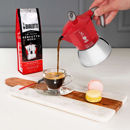 Red Bialetti Moka Induction stovetop coffee maker from Brew Italia, showcasing its classic design and sturdy hardware.