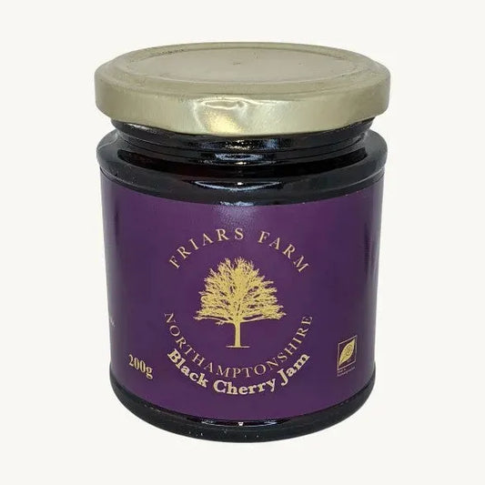 Close-up of Friars Farm Black Cherry Jam in a jar, showing dark cherry jam with a glossy texture and rich color.