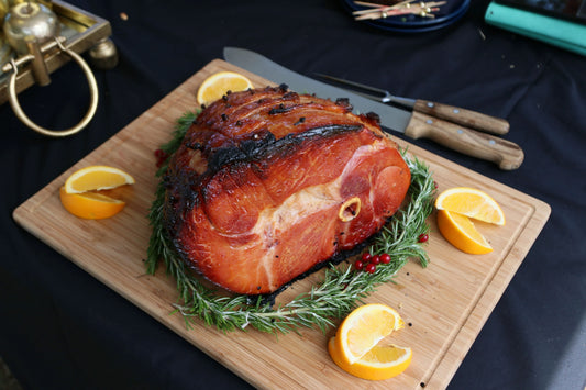 Cooked bone-in Gammon joint from Primrose Herd, showcasing a juicy, tender ham with visible bone and a glistening glaze.