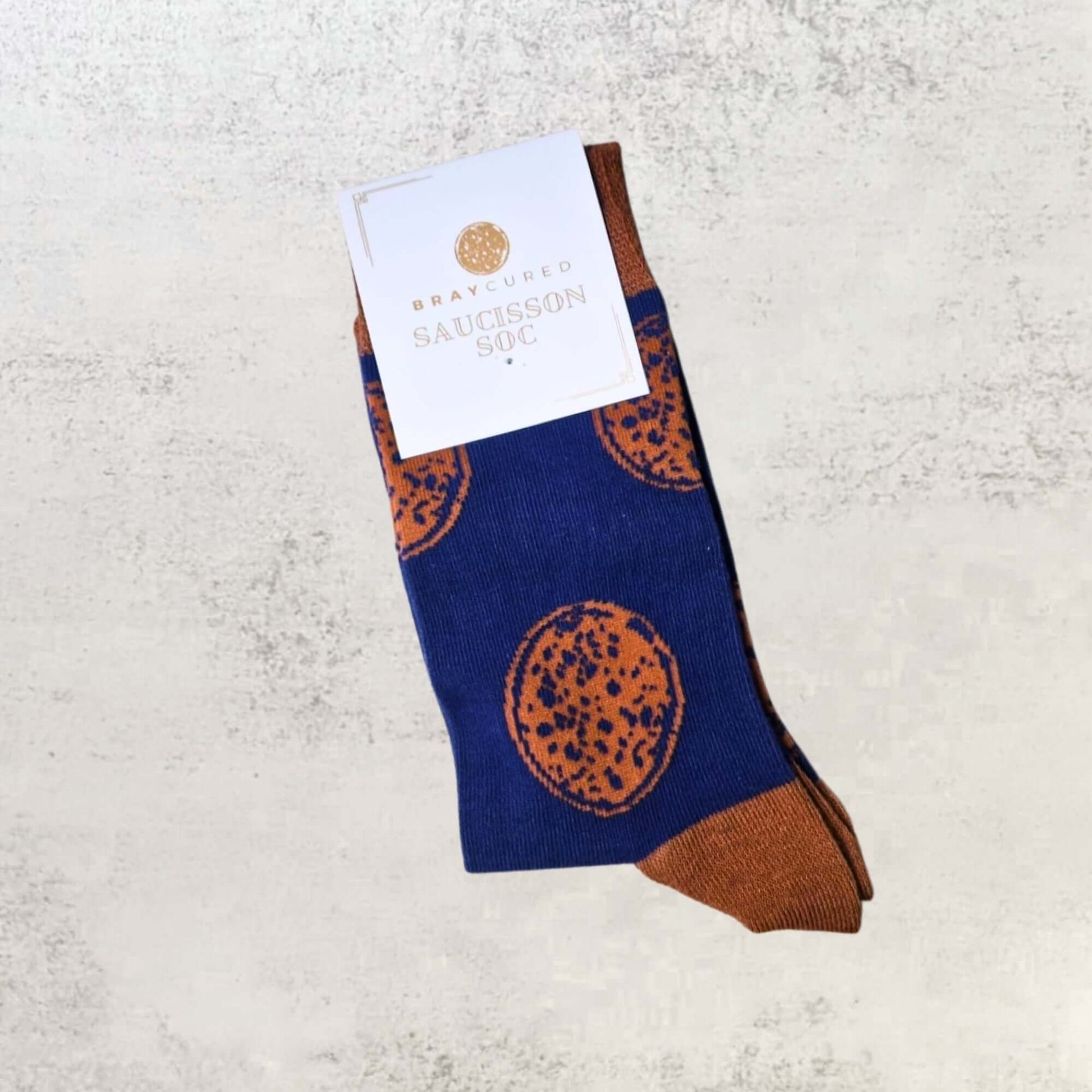 Charcuterie-themed socks by Bray Cured featuring sausage and meat patterns, perfect as a gift add-on accessory.