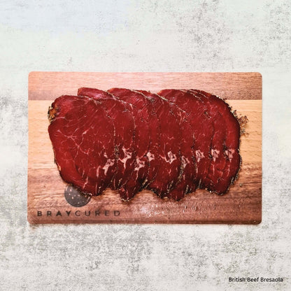 British beef Bresaola slices on a charcuterie board with complementary items, paired with British Red Wine in an elegant hamper by Bray Cured.