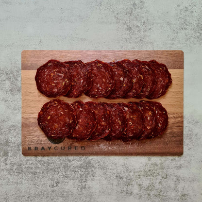 Sliced British Pepperoni from Bray Cured on a charcuterie board with cheese and crackers, showcasing its rich, flavorful appearance.