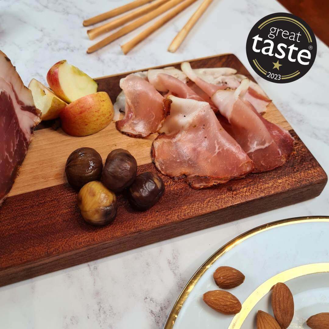 Sliced British Lomo charcuterie from Bray Cured arranged on a wooden board, showcasing its cured pork loin.