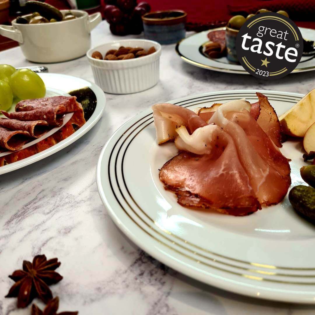 Thinly sliced British Bray Cured Classic Lomo charcuterie pork loin on a plate, showcasing its rich, cured meat texture.