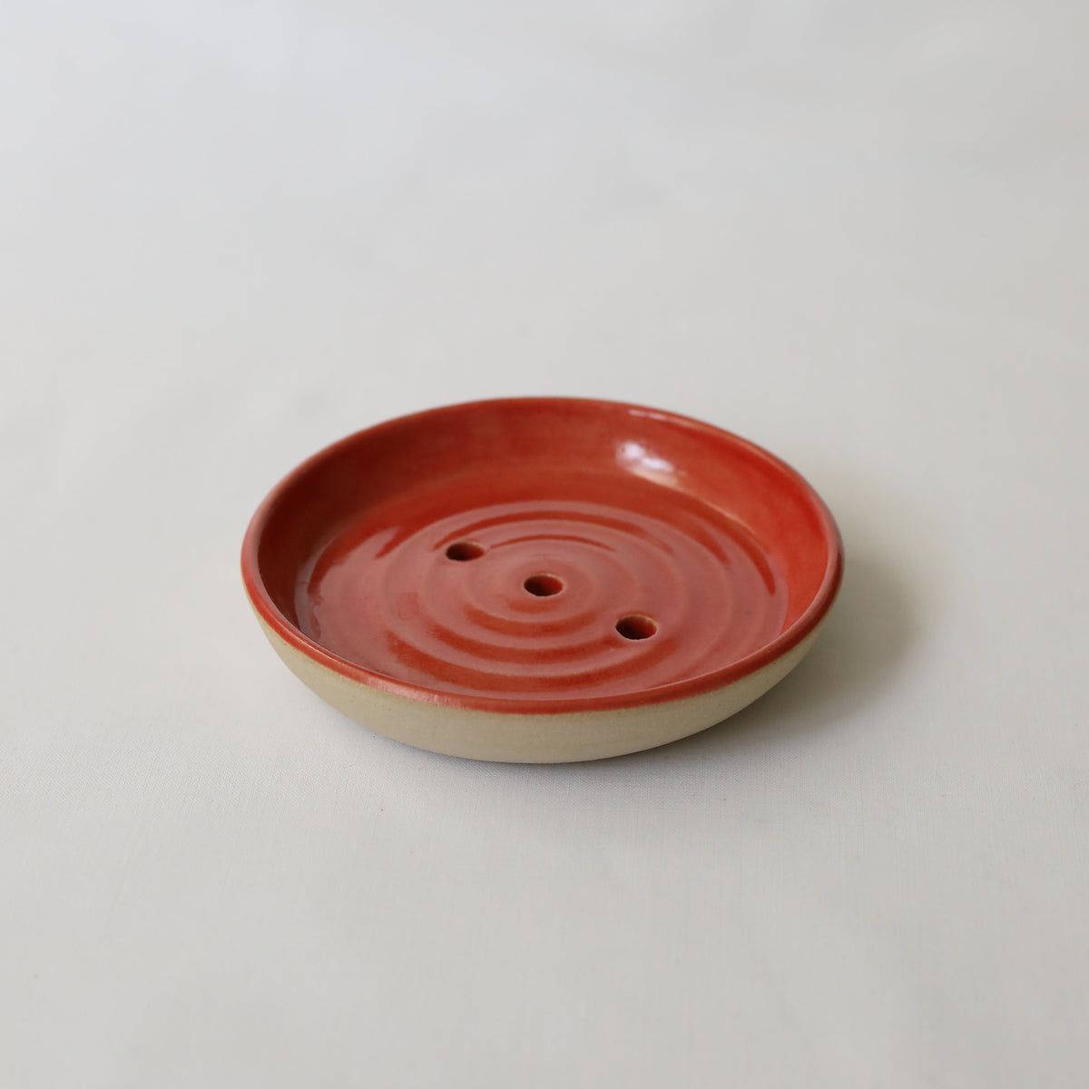 Cherry red ceramic soap dish by Katie L Thompson Designs, featuring a classic, curved design for bathroom or kitchen use.