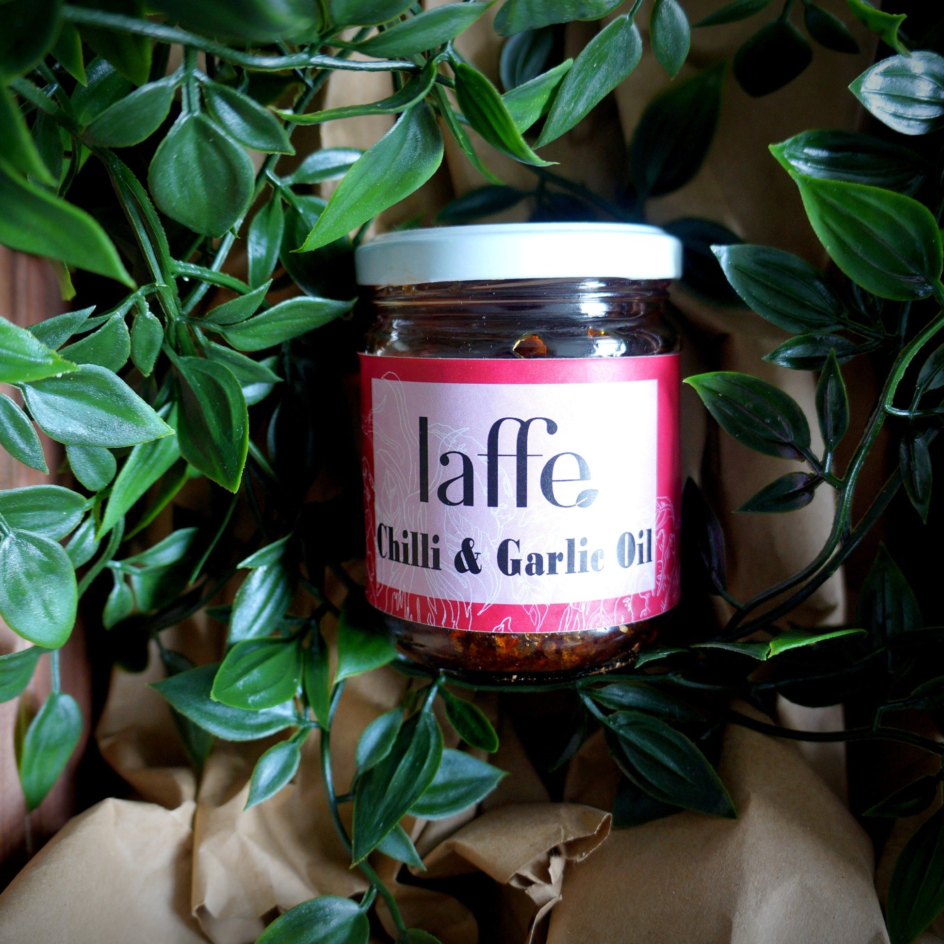 Jar of 'laffe Chilli & Garlic Oil' surrounded by green leaves