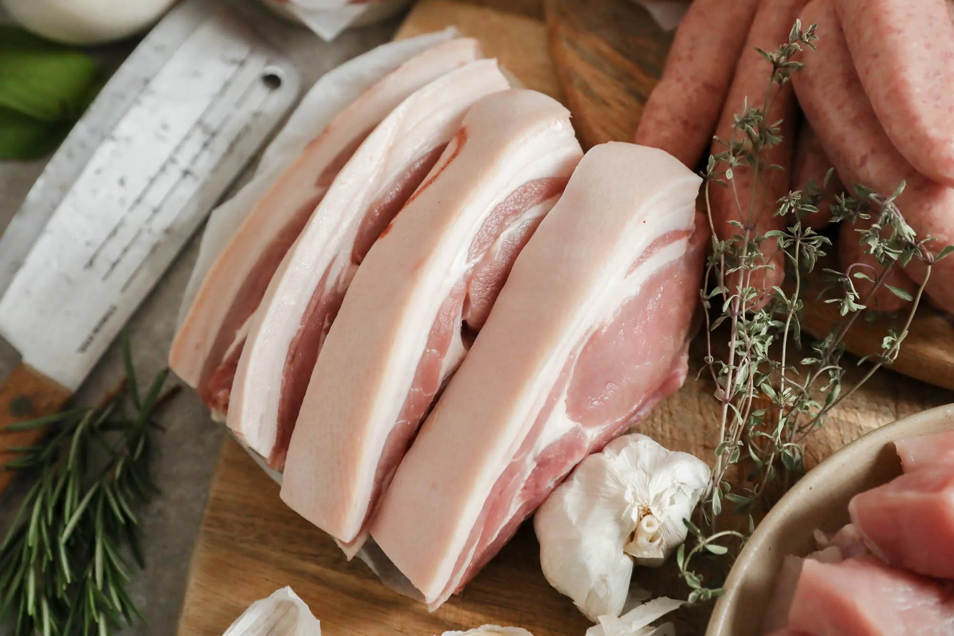 Assorted pork chops from Primrose Herd Family Pork Box, showcasing fresh, uncooked meat cuts on a white background.