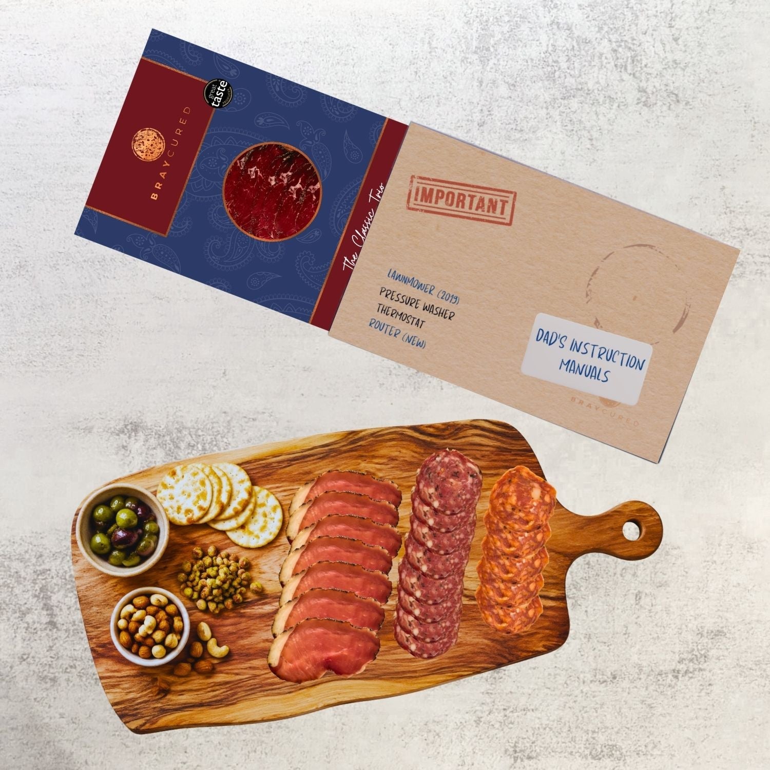 Bray Cured Classic Tasting Trio charcuterie selection on a wooden board with instruction manuals and a sleeve.