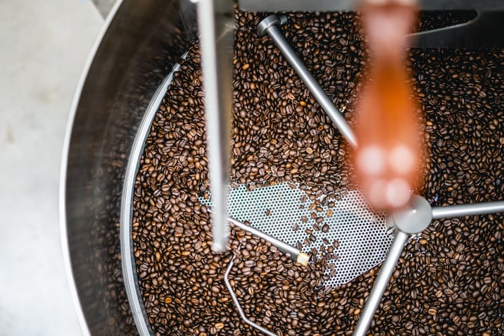 Decaf coffee beans cooling in a drum roaster at Clubhouse Roastery, part of the Nightwatchman decaf coffee production process.