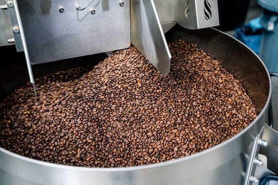 Dark roast heavyweight blend coffee from Clubhouse Roastery cooling on a coffee roaster’s cooling tray.
