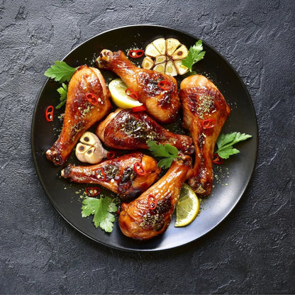 Cooked Creedy Carver free-range chicken drumsticks from Primrose Herd, showing juicy, well-seasoned poultry on a plate.