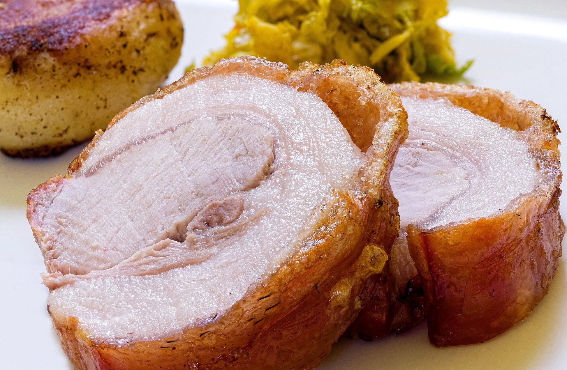 Cooked French Trimmed Loin of Pork joint from Primrose Herd, showcasing a golden-brown roasted pork loin with crispy edges.
