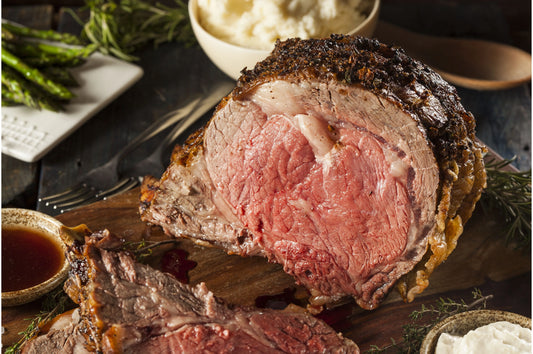 Cooked dry-aged Rib of Beef joint from Primrose Herd, showcasing tender, flavorful beef with a crispy crust on a serving platter.