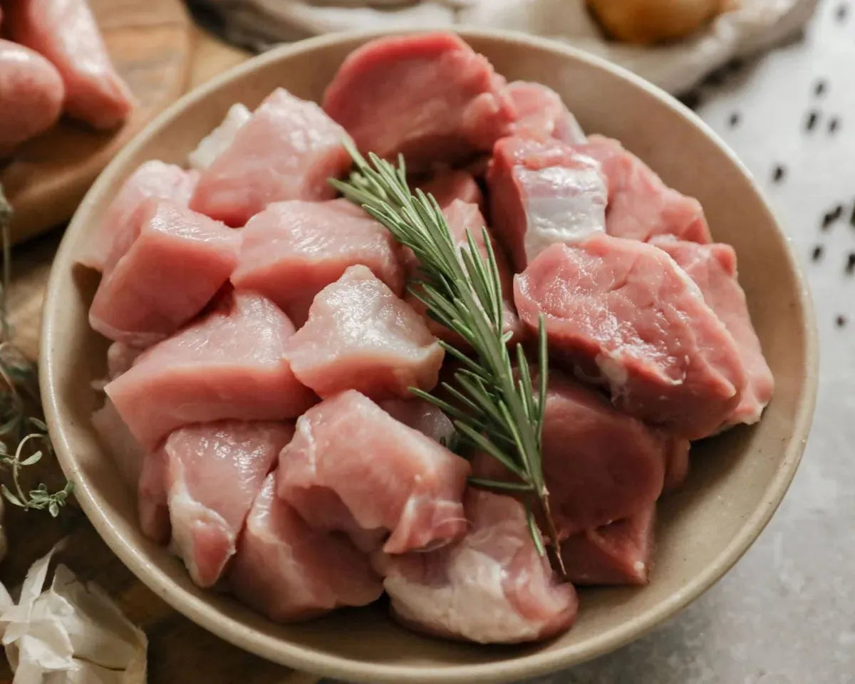 Cubed diced pork from Primrose Herd, showing evenly cut pink pork pieces suitable for cooking or recipes.