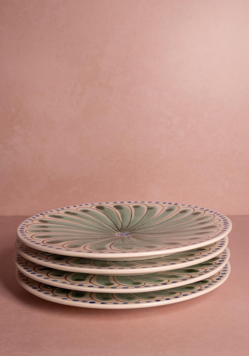Set of four green Casa by Josephine Jenno Peacock dinner plates with intricate peacock feather designs.