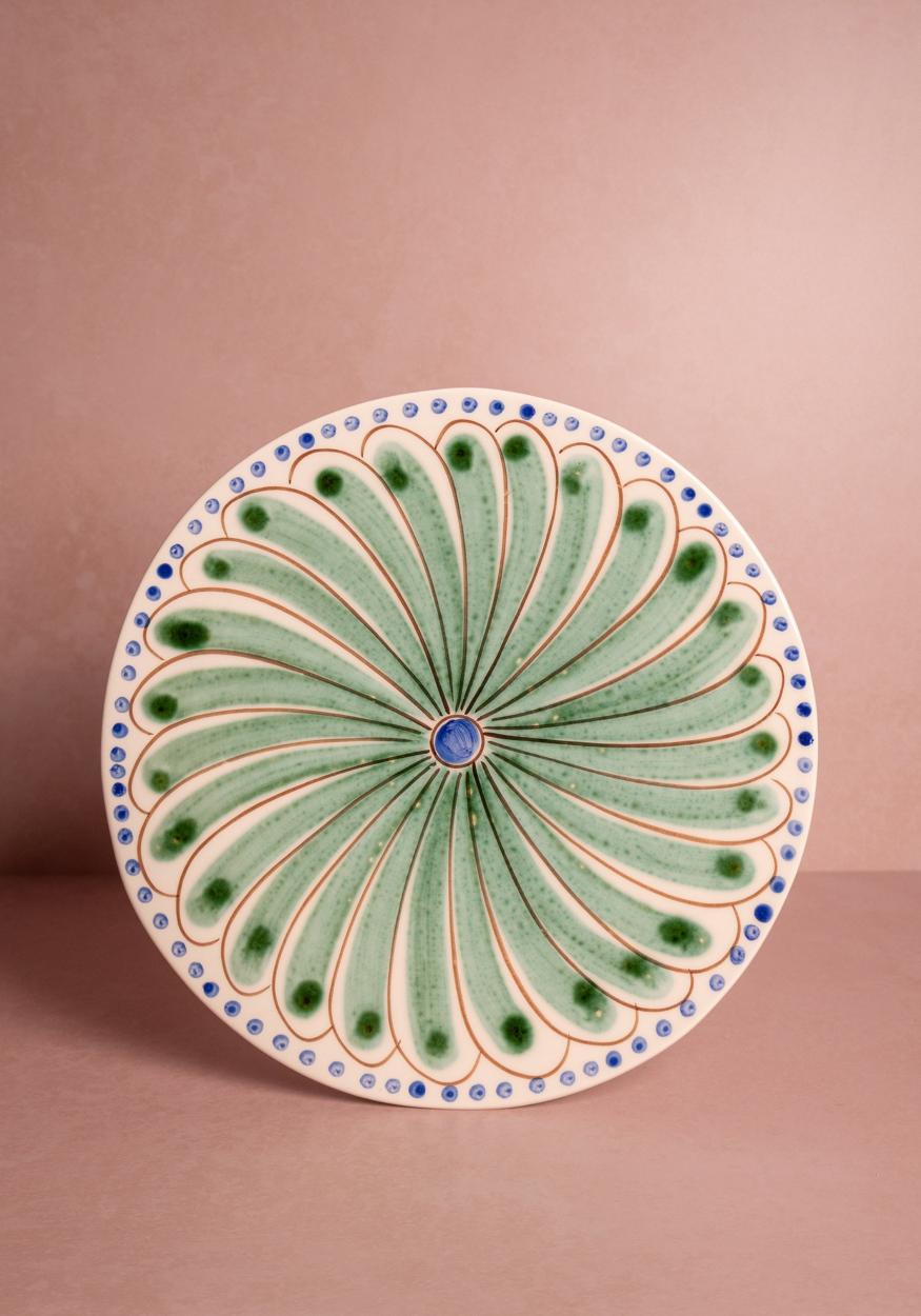 Set of four green Casa by Josephine Jenno Peacock dinner plates with intricate peacock feather designs.