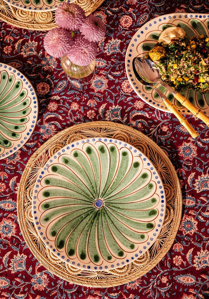 Set of four green Casa by Josephine Jenno Peacock dinner plates with intricate peacock feather designs.