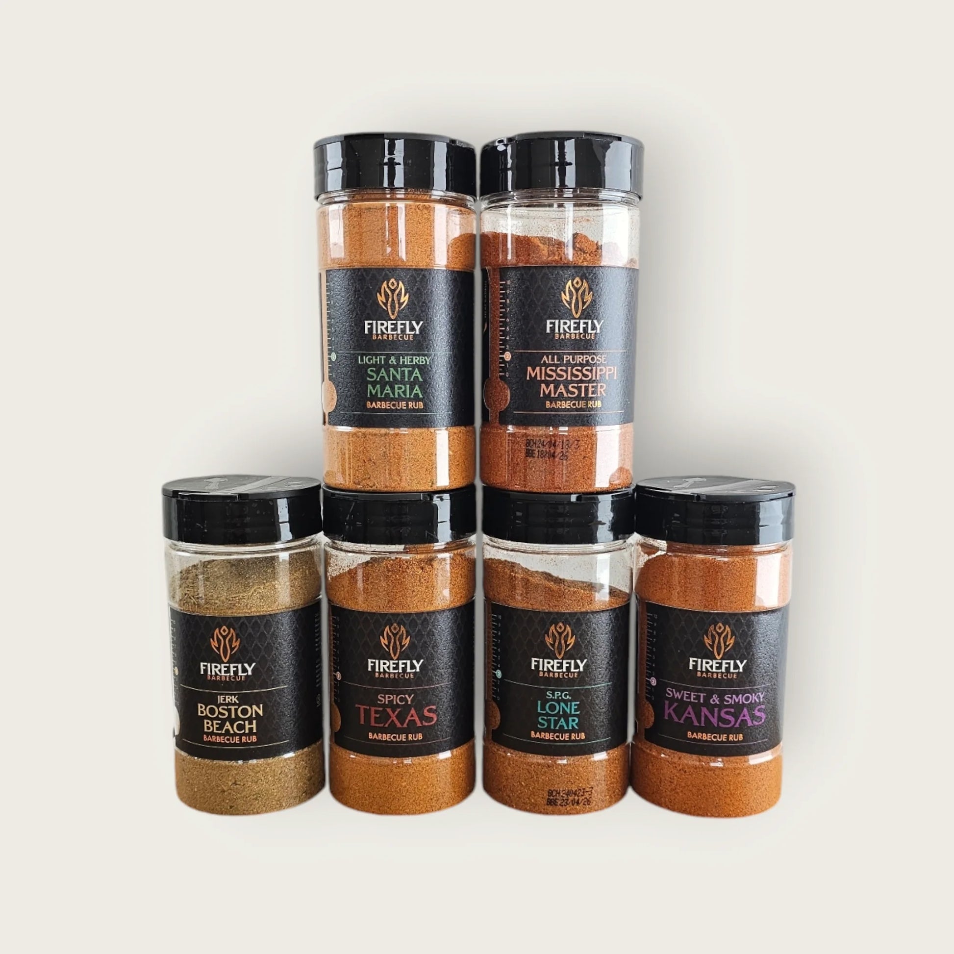 FireFly Barbecue BBQ Rub Selection Pack with 6 jars, showcasing various spice blends in clear jars on a wooden surface.