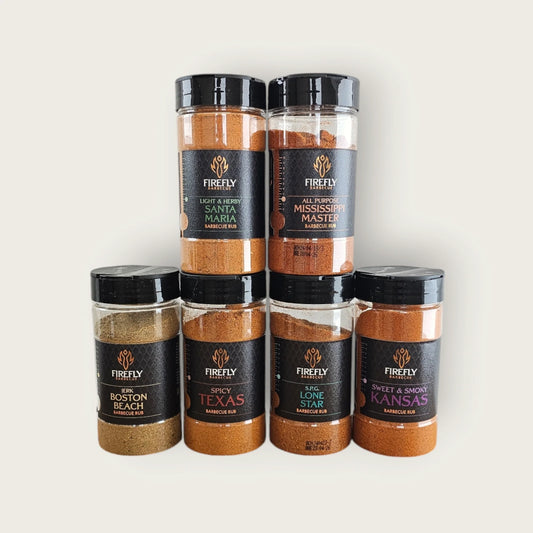 FireFly Barbecue BBQ Rub Selection Pack with 6 jars, showcasing various spice blends in clear jars on a wooden surface.